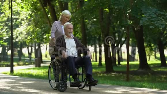 成年夫妇在公园散步妻子亲吻残疾丈夫康复视频的预览图