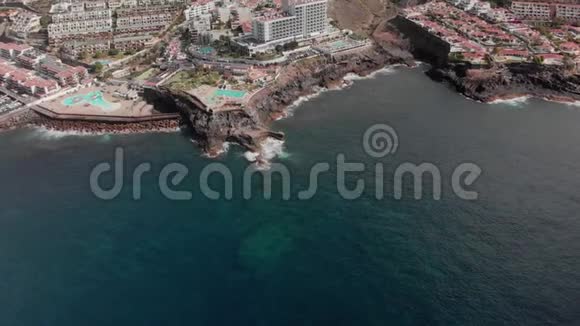 空中射击旅游城市有许多酒店和游泳池在大西洋海岸海浪冲击着火山视频的预览图
