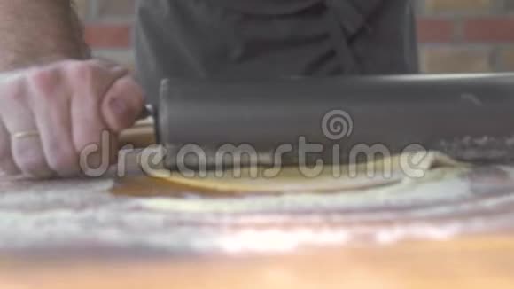 用滚筒在木板上做自制比萨饼用滚筒煮薄面团用擀面杖处理酵母面团视频的预览图