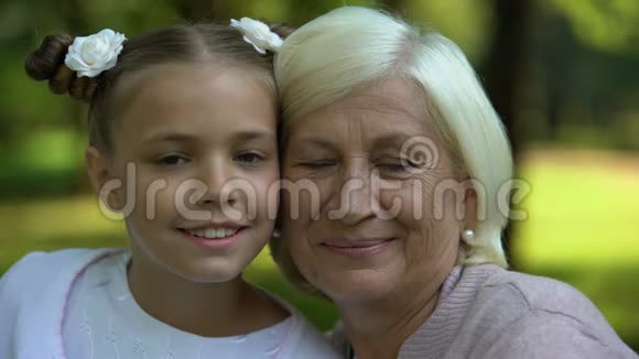 幸福的祖母和孙女拥抱摆姿势拍照家庭价值观视频的预览图