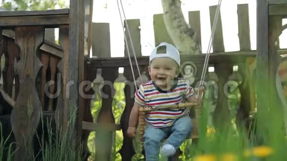 快乐的小男孩在秋千上慢镜头视频的预览图