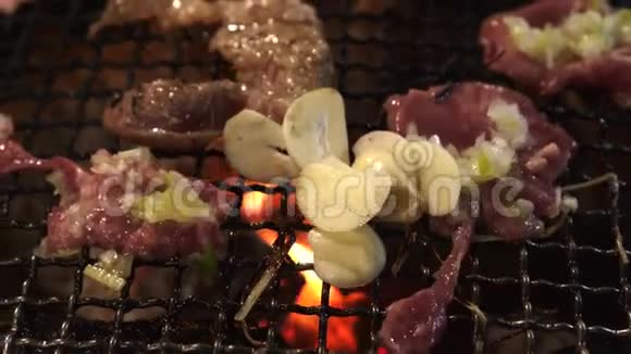 日本烧烤炉用木炭烤牛肉红火烤大蒜视频的预览图