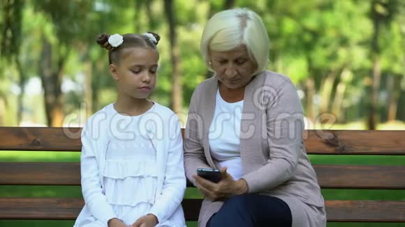 聪明的女孩教她祖母如何使用智能手机现代技术视频的预览图