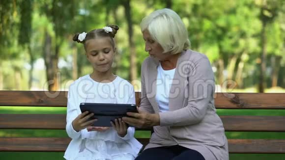 孙女用现代平板电脑教学奶奶视频的预览图