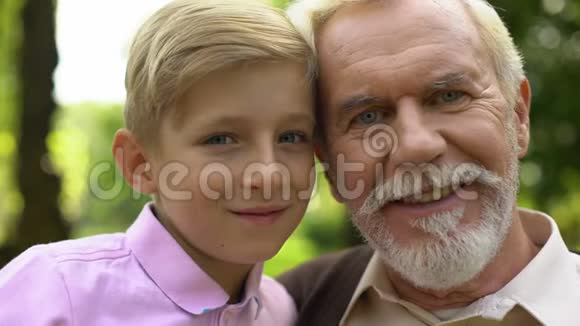 男孩和老人摆着相机微笑着信任与祖父的关系视频的预览图