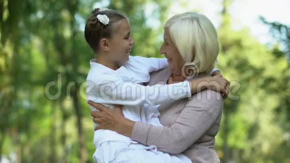 可爱的孙女坐在祖母的膝上信任的关系家庭视频的预览图