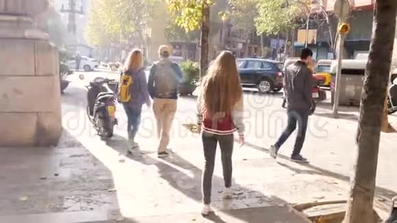 在欧洲的城市街道散步的青少年的后景快乐女孩探索大城市看着相机微笑视频的预览图