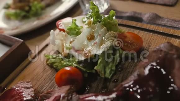 餐厅桌子上放着生菜和樱桃番茄的牛排视频的预览图