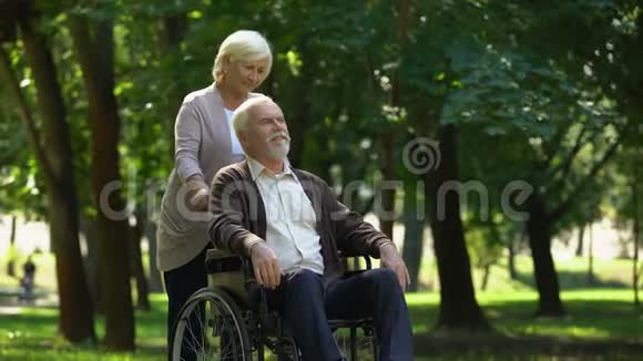 关爱的女人在轮椅上支持丈夫亲吻对方家人视频的预览图