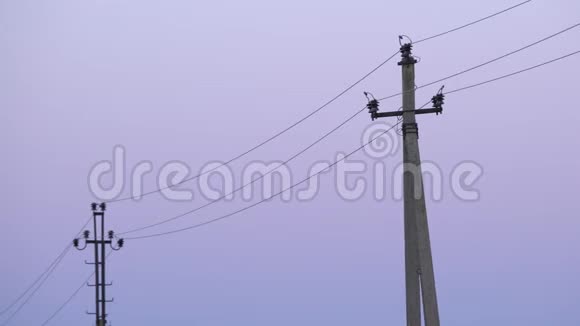 黄昏时分村里的旧混凝土电线杆带有高压电缆和色彩缤纷的黎明天空的俄罗斯电线杆视频的预览图