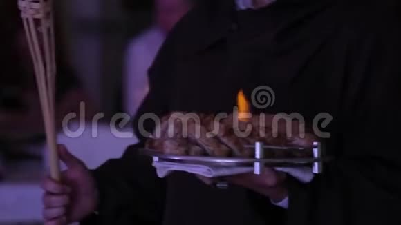服务员手中盘子上有火焰的肉片的特写镜头视频的预览图