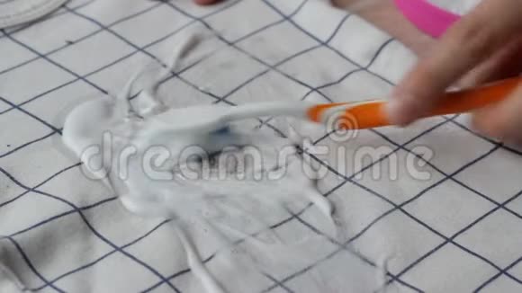 女孩用去污剂清洗婴儿衣服上的污渍特写干洗家用视频的预览图
