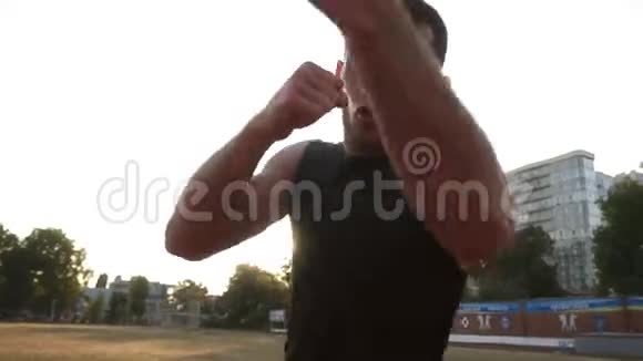 一个在户外运动的年轻拳击手的加速手持射击男子拳击与隐形对手的肖像视频的预览图