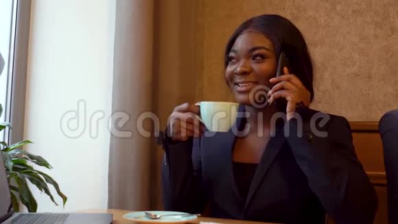 非裔美国女商人与生意伙伴通电话喝咖啡视频的预览图
