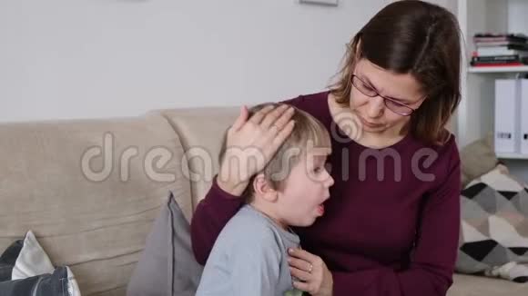 可爱的小男孩在咳嗽和他的母亲坐在客厅里视频的预览图