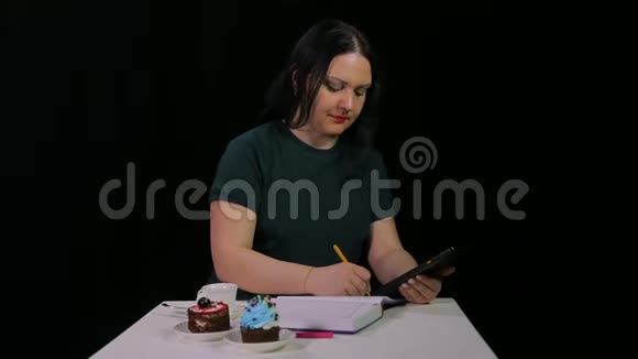 一个棕色头发的女孩在咖啡馆里和一块药片一起工作喝咖啡视频的预览图