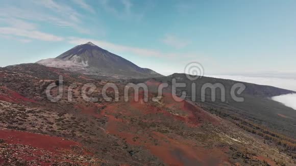 空中射击在火山峰和高山松针和高山森林背景下的云层上方飞行视频的预览图