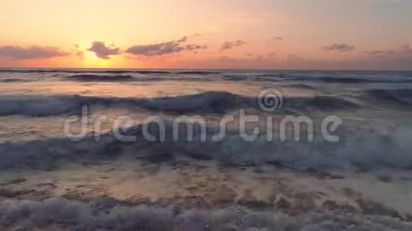 热带海滩和美丽的海上日出戏剧性的云彩和舞动的波浪视频的预览图
