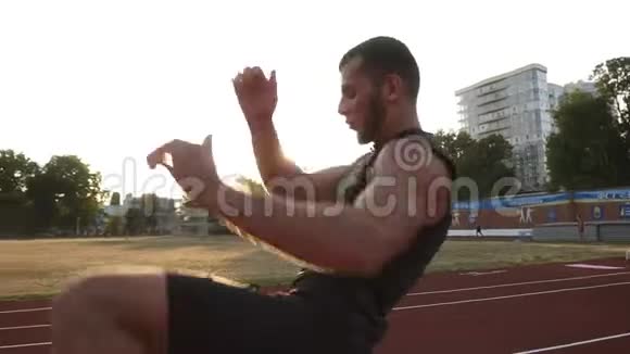 一个年轻拳击手在球场上的训练过程练习踢腿踢球穿着黑色运动服视频的预览图