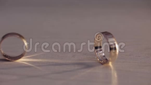 两个结婚戒指在地板上滚动视频的预览图