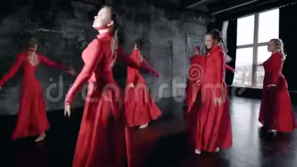 一群穿红色连衣裙的漂亮女孩一起在一个演播室里跳舞集体舞蹈排练视频的预览图