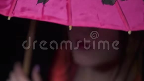 可爱的日本女人从伞下露出可爱的微笑闭上眼睛视频的预览图