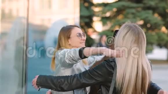 女孩团聚年轻朋友拥抱城市街道视频的预览图