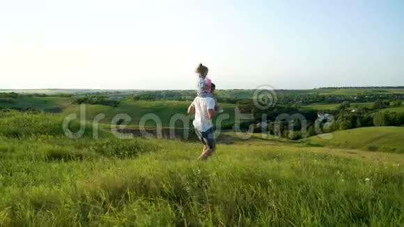 父亲和女儿在草地上共同散步视频的预览图