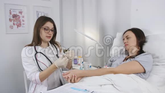 一位年轻的女医生准备一个注射器注射院病人的治疗视频的预览图