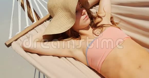 高角度视角的高加索女人在海滩4k的吊床上放松视频的预览图