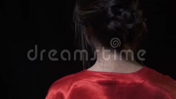 可爱的日本女孩在举起红色扇子时转过身视频的预览图