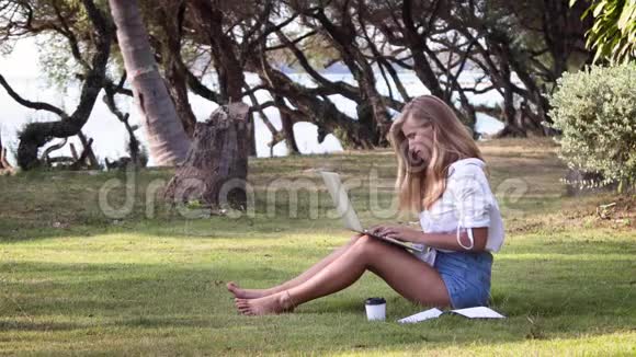女学生在暑期公园的笔记本上在线学习视频的预览图