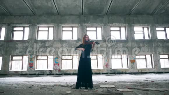 美丽的女人正在一个搁浅的房间里拉小提琴视频的预览图