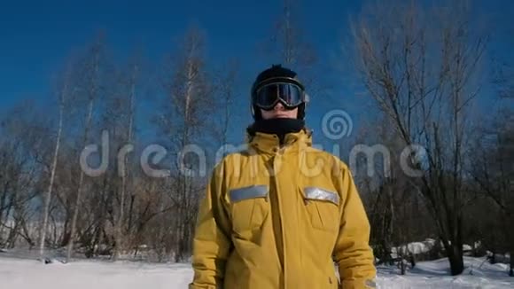 穿黄色夹克衫的特写记者滑雪板在冬天的城市公园里环顾四周视频的预览图