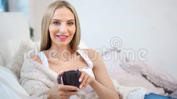 中等特写照片美丽的微笑的女人裹着格子手捧杯子视频的预览图