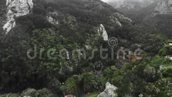 空中射击两山之间的峡谷中一个风景如画的高原村庄低雷雨云和视频的预览图