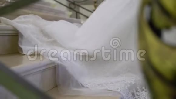 穿白色婚纱的年轻新娘走下楼梯视频的预览图