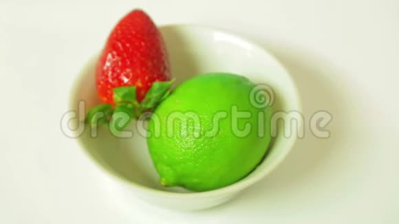 青柠果和熟了的草莓在一个白色的盘子里旋转一圈从上面看视频的预览图