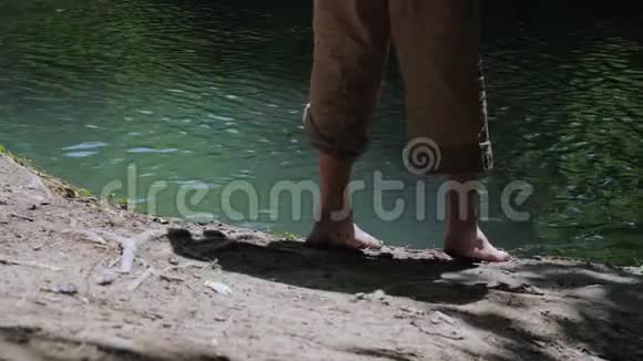 两个穿着脏衣服光着脚在河岸上游荡的男孩视频的预览图