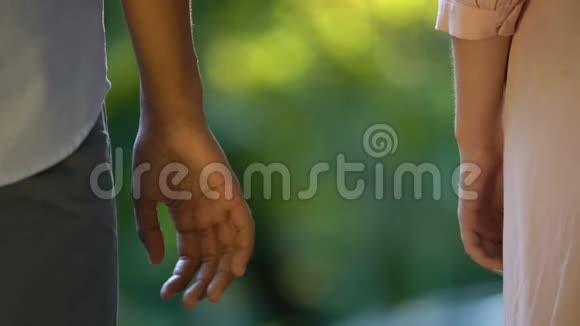 多民族情侣在公园牵手的后景温柔的浪漫情怀视频的预览图