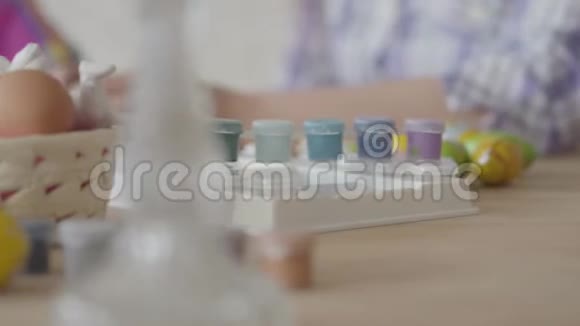 女人从篮子里拿出一个鸡蛋母女俩在厨房里画复活节彩蛋小型丙烯酸视频的预览图