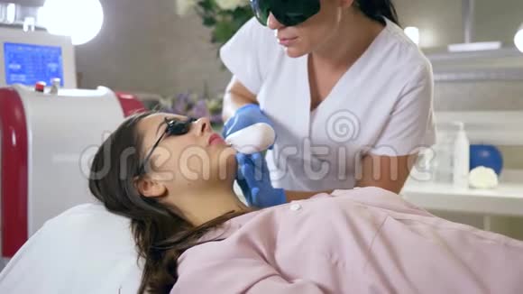 美容专家在美容院使用激光设备对客户妇女面部进行脱毛视频的预览图