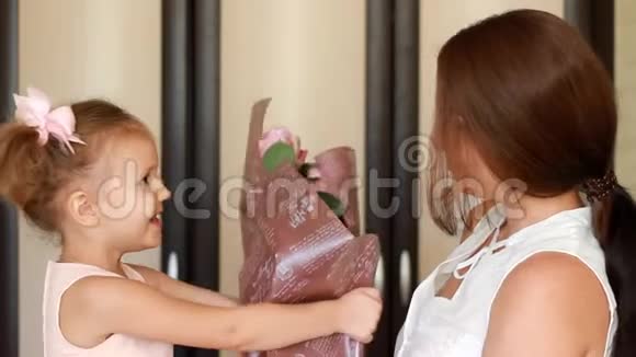 母亲日子或生日的概念妈妈和女儿带着一束鲜花玫瑰视频的预览图