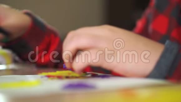 一个十几岁的男孩用剪刀剪掉多余的塑料他用塑料制作了一个3D图形视频的预览图