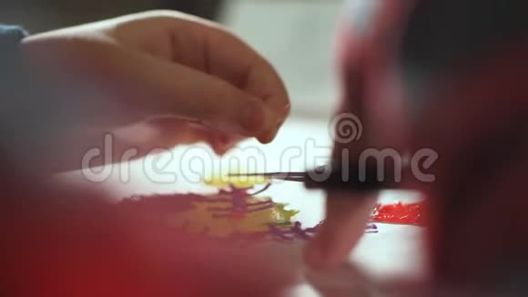 一个十几岁的男孩用剪刀剪掉多余的塑料他用塑料制作了一个3D图形视频的预览图
