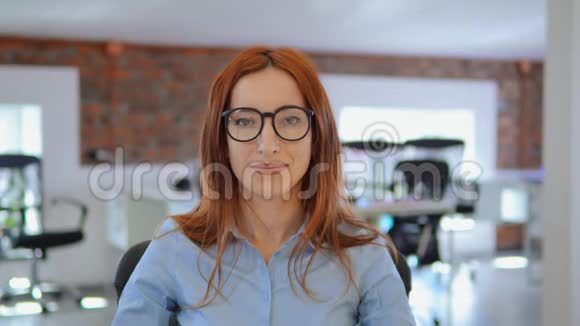 肖像红发妇女在工作场所微笑视频的预览图