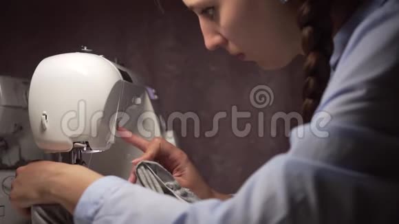 女人用灯把衣服缝在缝纫机上时尚创造和剪裁视频的预览图