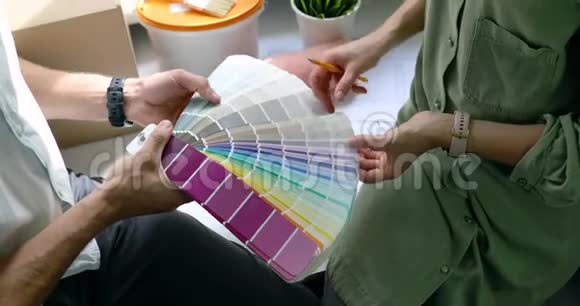 人们讨论和选择油漆颜色从样本为新的家庭室内设计视频的预览图