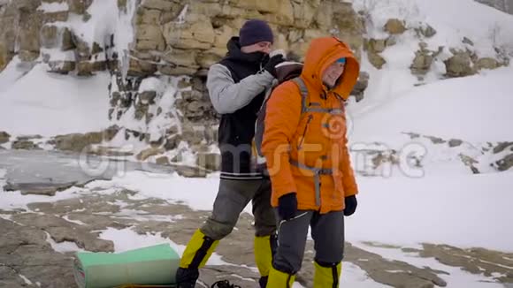 两个人去冬季远足朋友们有专业的设备他们沿着悬崖走视频的预览图