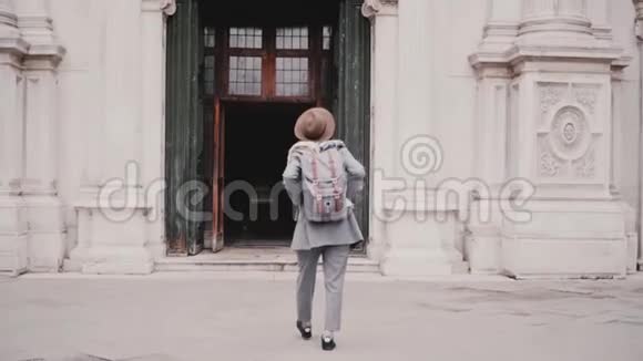 镜头跟随年轻时尚的女游客走进意大利威尼斯圣马可大教堂的大门慢动作视频的预览图
